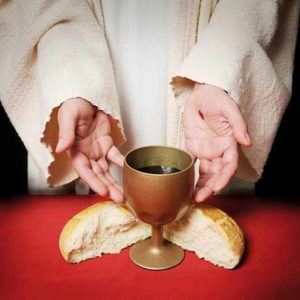 The hands of Jesus offering the Communion wine and bread